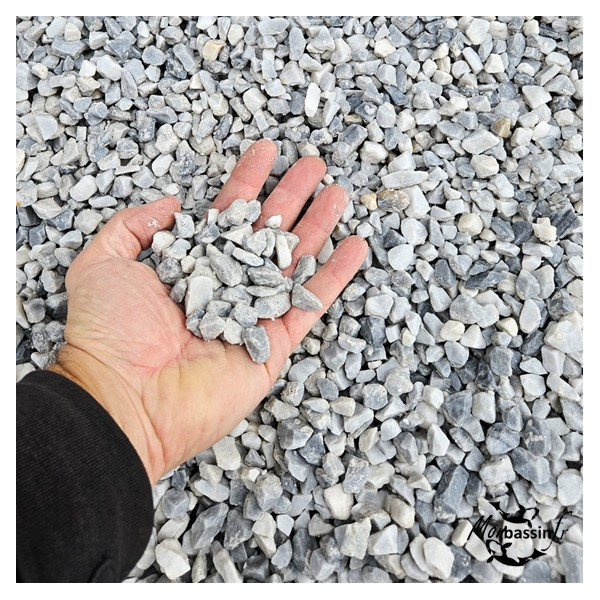 Gravier Baltic 8/16 mm dans la main gros plan teintes gris-bleu et blanc MonBassin