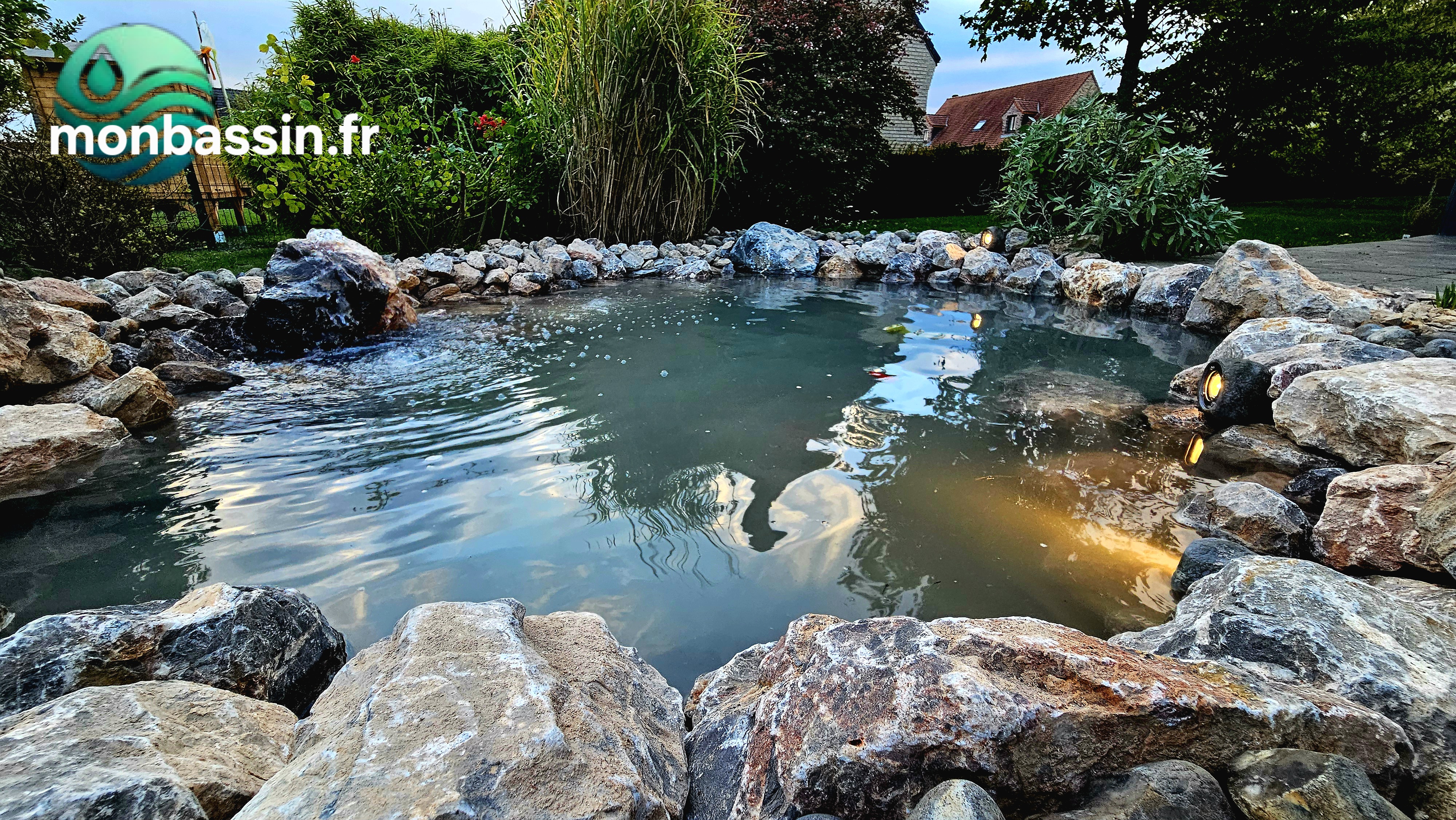 Bassin de jardin éclairé la nuit avec pierre percée fontaine