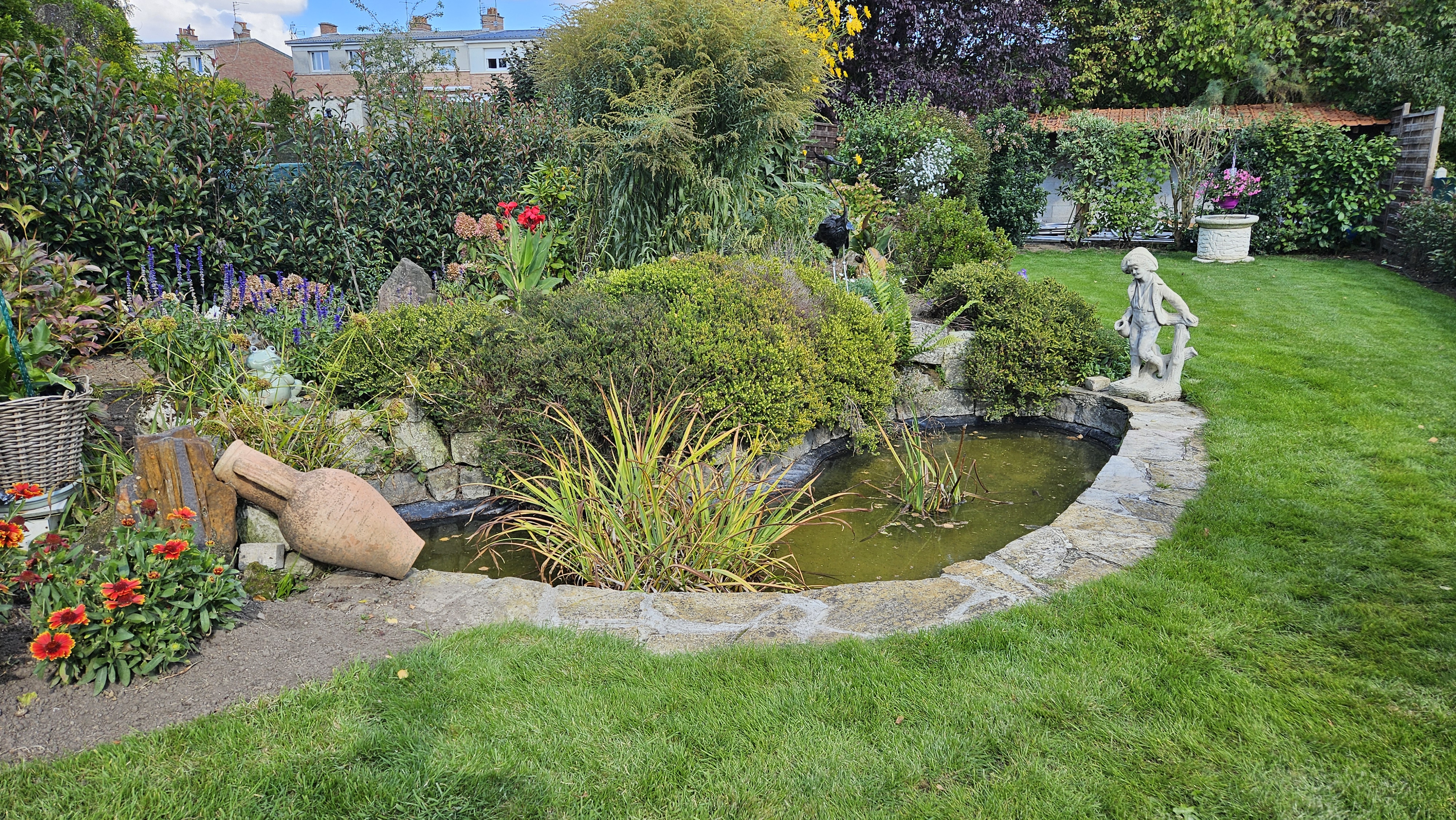 Bassin en béton fissuré avec cascade en dalles de récupération, découvert après l'achat d'une maison